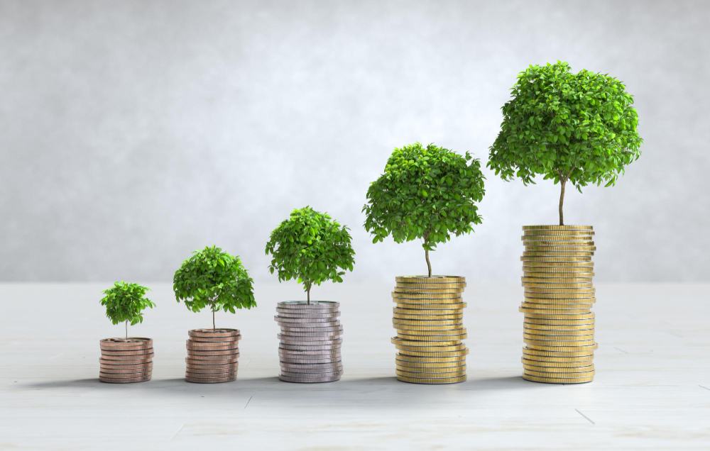 Stacks of coins with small trees growing from them, representing careful financial planning